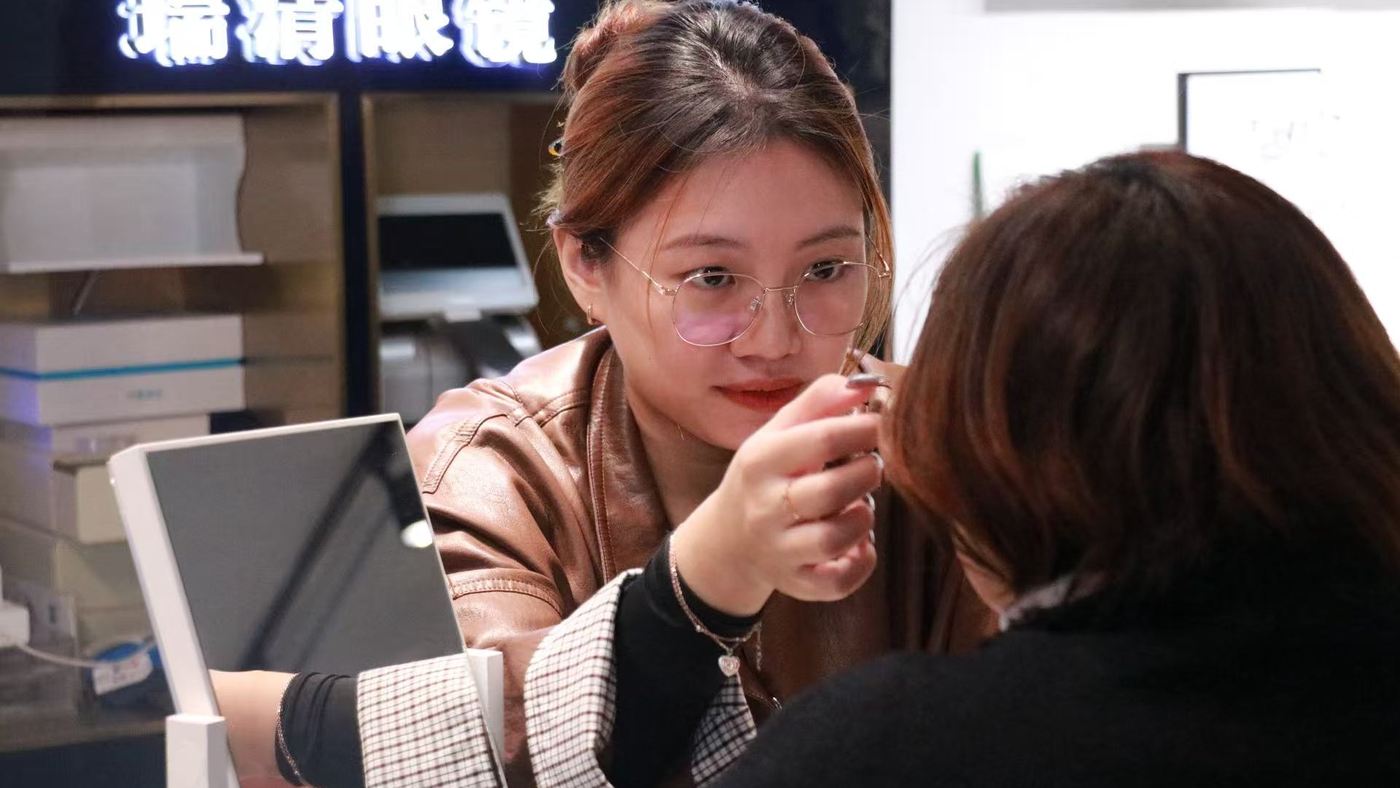 瑞清眼镜门店为成人顾客调整试戴眼镜