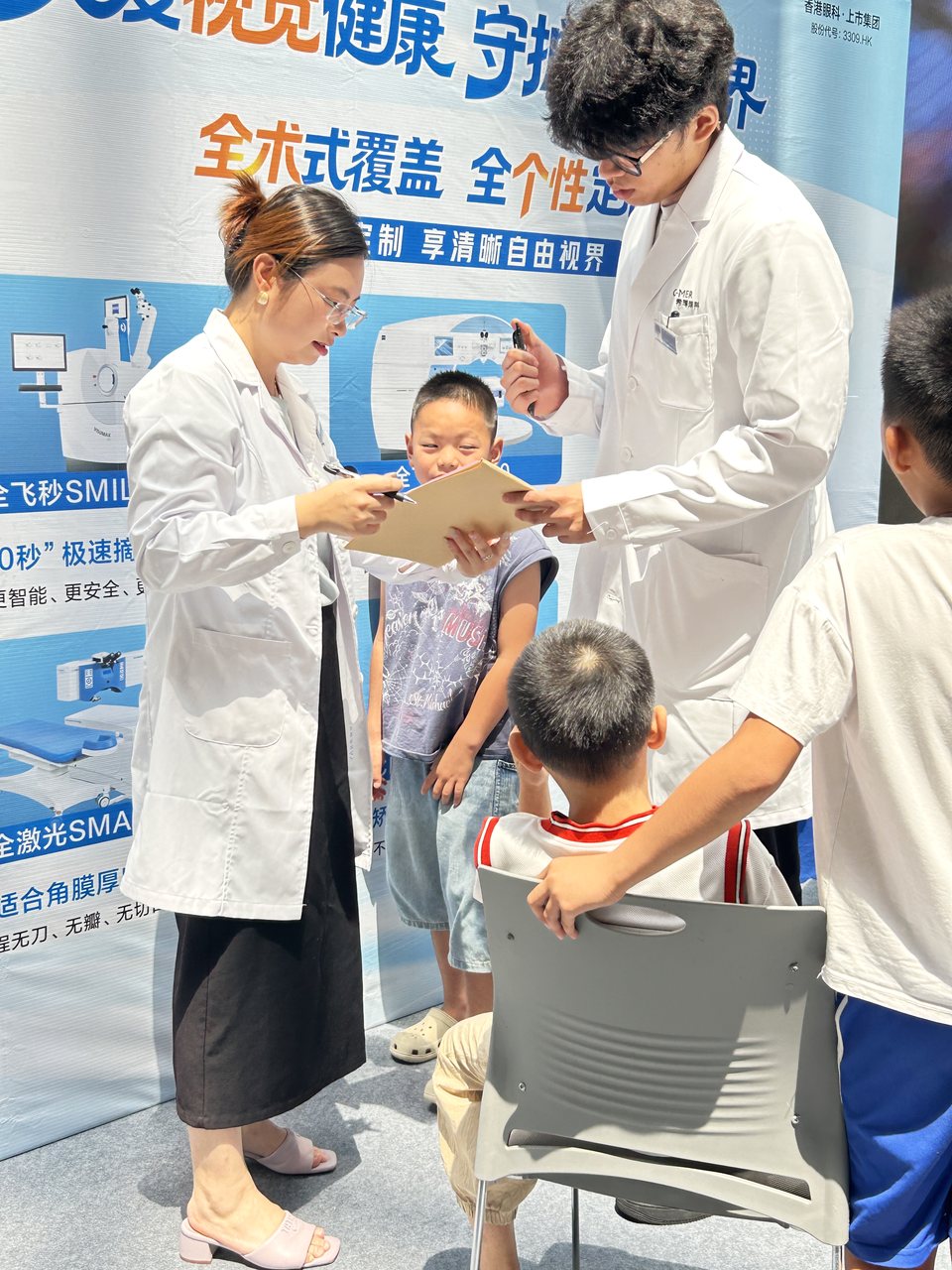 公益活动工作人员陪伴儿童完成眼健康服务
